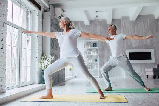 elderly couple practicing yoga to support balanced hormones